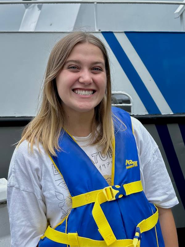 Anna Maki stands dockside next to the R/V W.G. Jackson